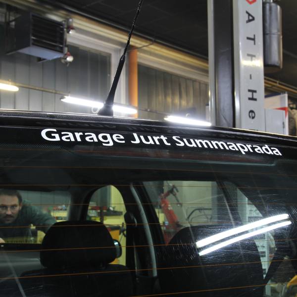 Schriftzug Garage Jurt Summaprada auf einer Heckscheibe