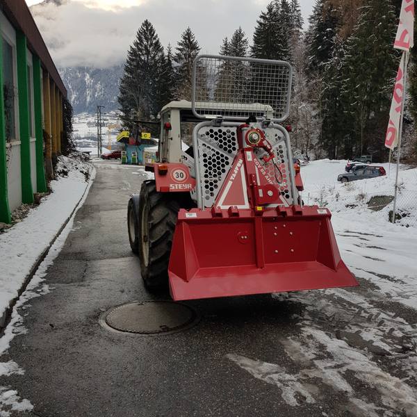 Traktor mit Seilwinde im Schnee
