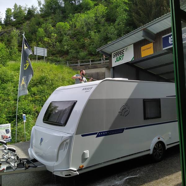 Wohnwagen beim Unterstand mit Husqvarna-Schild